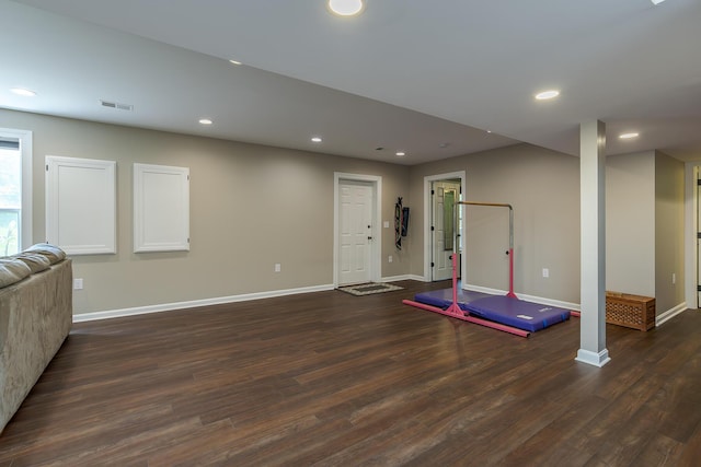 exercise area featuring baseboards, dark wood-style floors, and recessed lighting