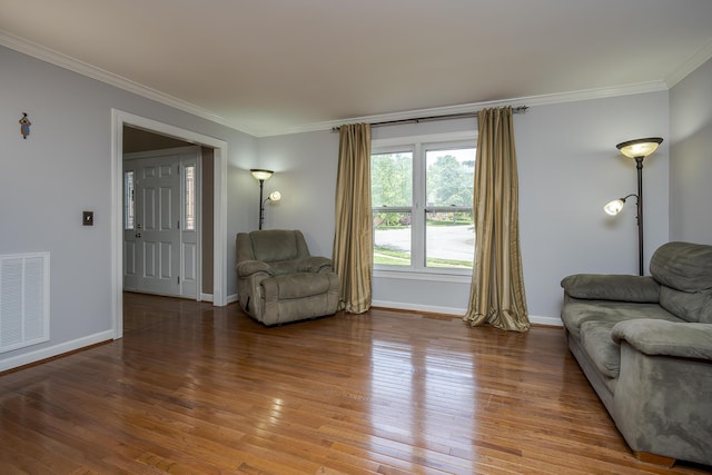 living area featuring crown molding, baseboards, and wood finished floors