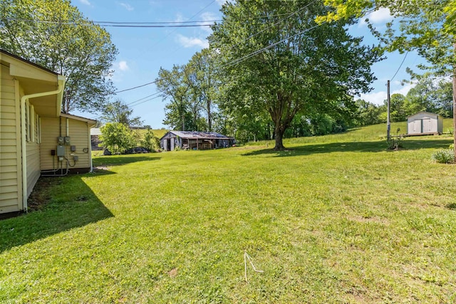 6362 E Laurel Rd, London, KY 40741 - view of grassy yard featuring a storage unit and an outbuilding