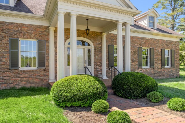 1373 Delong Cir, Lexington, KY 40515 - view of exterior entry with brick siding, roof with shingles, a yard, and covered porch