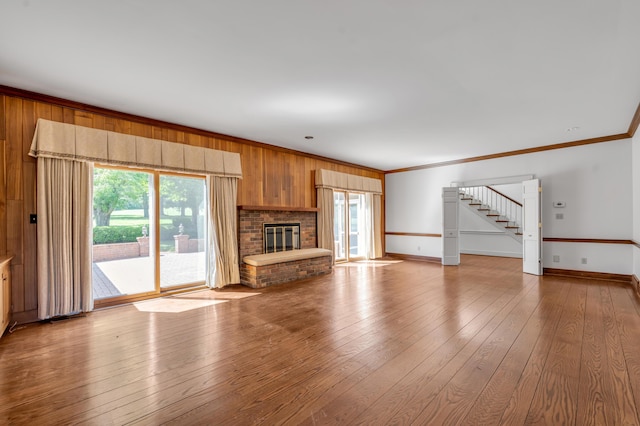 1373 Delong Cir, Lexington, KY 40515 - unfurnished living room featuring stairs, baseboards, hardwood / wood-style floors, crown molding, and a brick fireplace