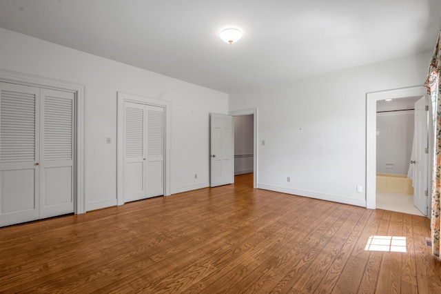 1373 Delong Cir, Lexington, KY 40515 - unfurnished bedroom with wood finished floors, multiple closets, baseboards, and connected bathroom