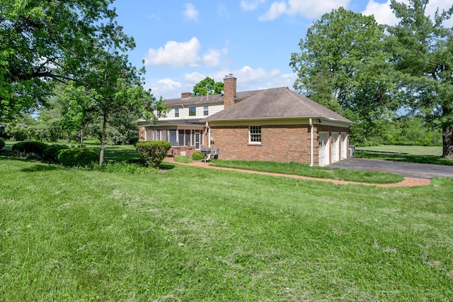 1373 Delong Cir, Lexington, KY 40515 - view of property exterior featuring brick siding, asphalt driveway, a lawn, a sunroom, and a chimney