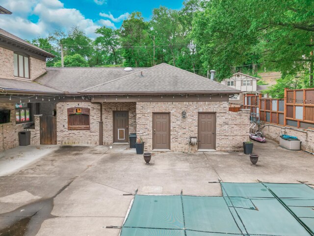 319 Fifth St, Paintsville, KY 41240 - back of property with a shingled roof, a patio area, and brick siding