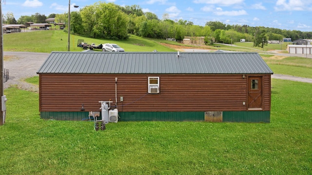 266 Boaters Aly, Nancy, KY 42544 - view of home's exterior featuring log veneer siding, a lawn, an outbuilding, and metal roof