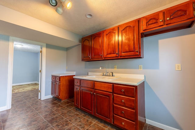 63 Harmons Way, Somerset, KY 42503 - kitchen featuring a sink, light countertops, baseboards, a textured ceiling, and dark tile patterned floors