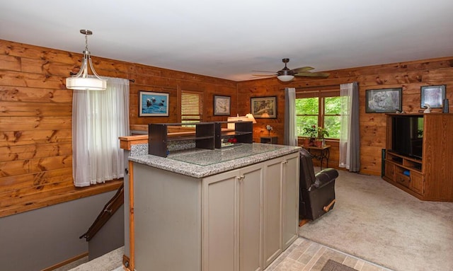 1220 Fox Wood Rd, Frankfort, KY 40601 - kitchen featuring wooden walls, ceiling fan, a kitchen island, light carpet, and hanging light fixtures