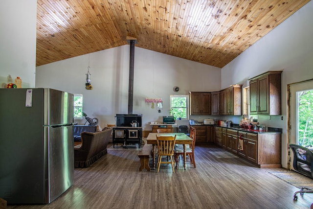 227 Callihan Rd, East Bernstadt, KY 40729 - kitchen with freestanding refrigerator, high vaulted ceiling, a wood stove, dark countertops, and dark wood-style flooring