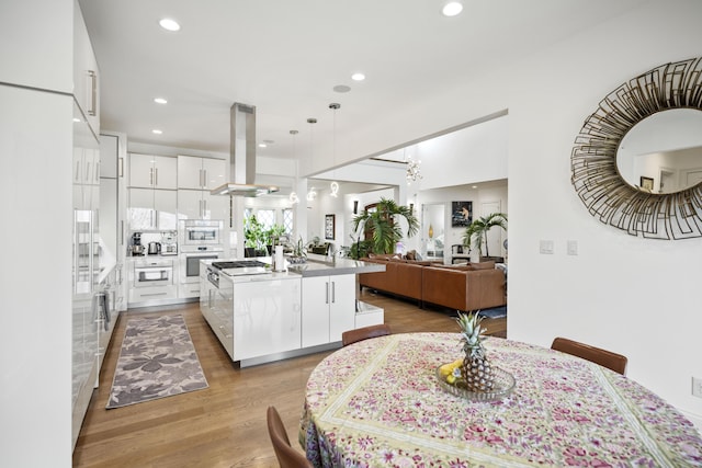 1782 W Leestown Rd, Midway, KY 40347 - kitchen with island exhaust hood, white cabinets, light wood-style floors, a center island with sink, and recessed lighting