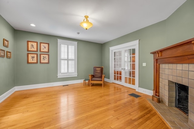 133 Victory Ave, Lexington, KY 40502 - unfurnished room with a tile fireplace, hardwood / wood-style floors, baseboards, french doors, and recessed lighting