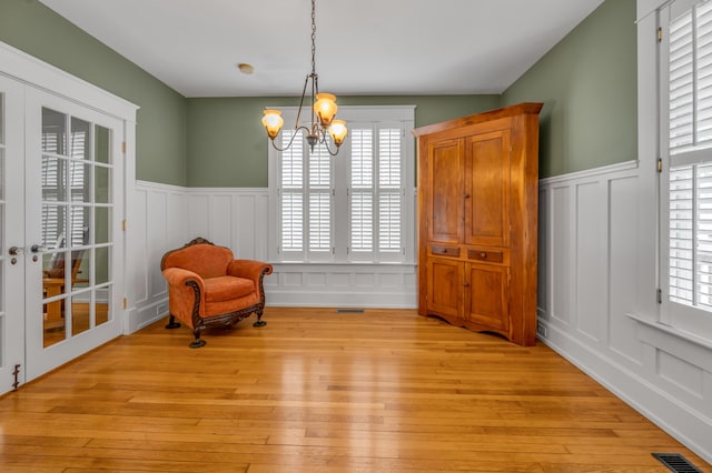 133 Victory Ave, Lexington, KY 40502 - living area featuring a decorative wall, wainscoting, a chandelier, and light wood-type flooring