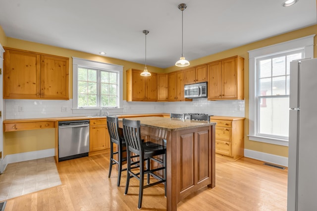 133 Victory Ave, Lexington, KY 40502 - kitchen featuring stainless steel appliances, light wood-style floors, baseboards, tasteful backsplash, and recessed lighting
