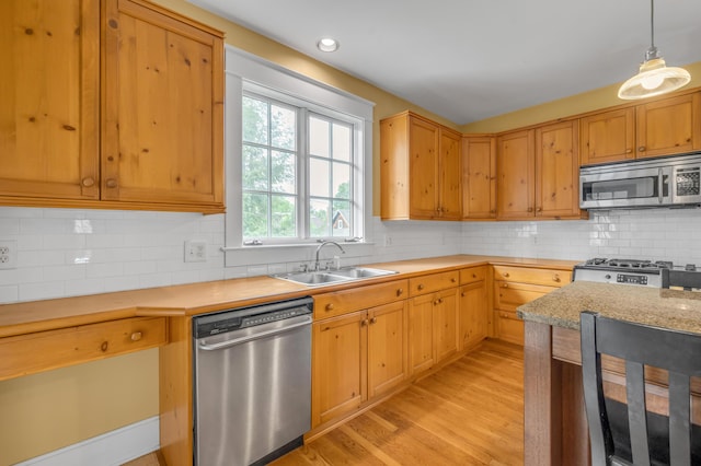133 Victory Ave, Lexington, KY 40502 - kitchen featuring stainless steel appliances, a sink, light wood-style floors, decorative light fixtures, and decorative backsplash