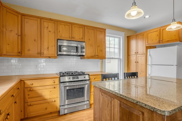 133 Victory Ave, Lexington, KY 40502 - kitchen with stainless steel appliances, backsplash, hanging light fixtures, and light stone countertops