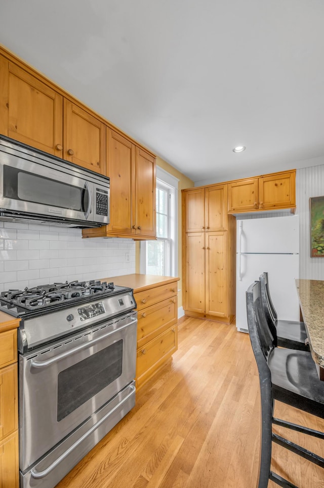 133 Victory Ave, Lexington, KY 40502 - kitchen with appliances with stainless steel finishes, light wood-style flooring, tasteful backsplash, light countertops, and recessed lighting