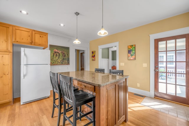 133 Victory Ave, Lexington, KY 40502 - kitchen featuring freestanding refrigerator, light wood finished floors, a kitchen breakfast bar, a kitchen island, and baseboards