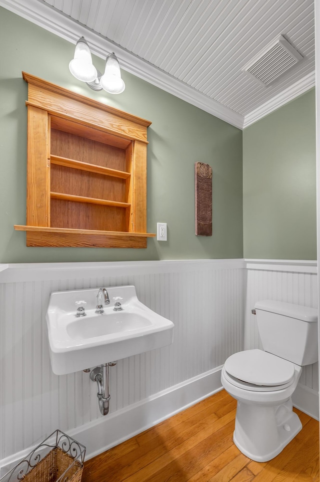 133 Victory Ave, Lexington, KY 40502 - bathroom featuring a wainscoted wall, wood finished floors, toilet, crown molding, and a sink
