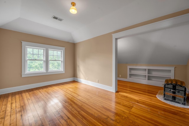 133 Victory Ave, Lexington, KY 40502 - unfurnished living room featuring wood-type flooring, lofted ceiling, and baseboards