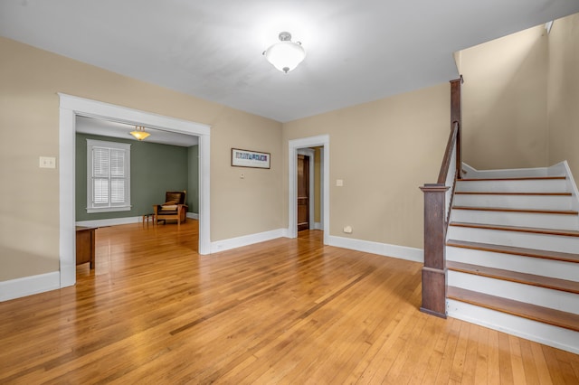 133 Victory Ave, Lexington, KY 40502 - unfurnished living room with light wood-type flooring, stairs, and baseboards