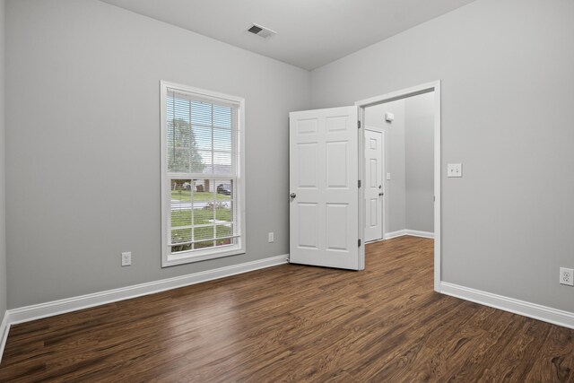 unfurnished room featuring dark wood-style flooring and baseboards