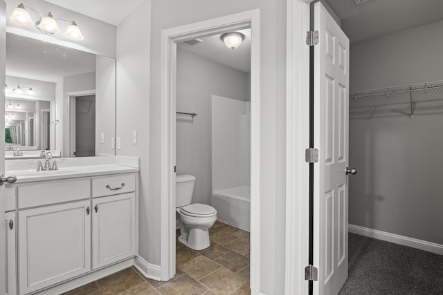 bathroom featuring toilet, vanity, and a spacious closet