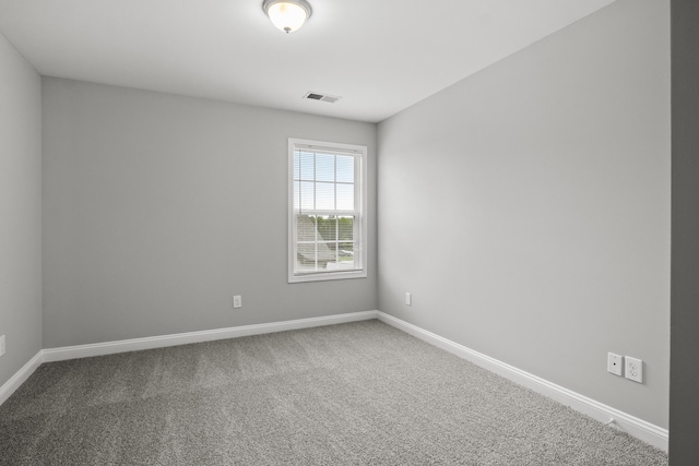 spare room featuring baseboards and carpet