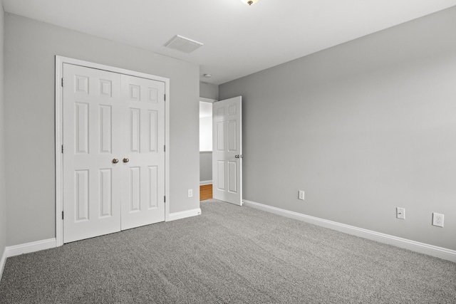 unfurnished bedroom featuring carpet flooring, a closet, and baseboards