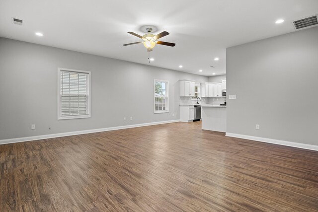 unfurnished living room with a ceiling fan, recessed lighting, dark wood finished floors, and baseboards