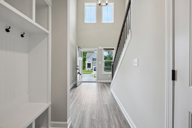 140 Peaceful Lndg, Georgetown, KY 40324 - mudroom featuring light wood-style flooring, baseboards, a chandelier, and a towering ceiling