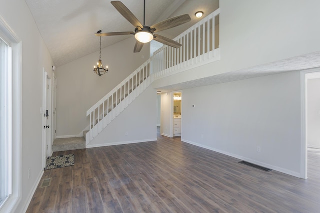 unfurnished living room featuring stairs, high vaulted ceiling, a ceiling fan, dark wood-style floors, and baseboards