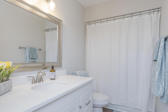 bathroom with toilet, vanity, and curtained shower