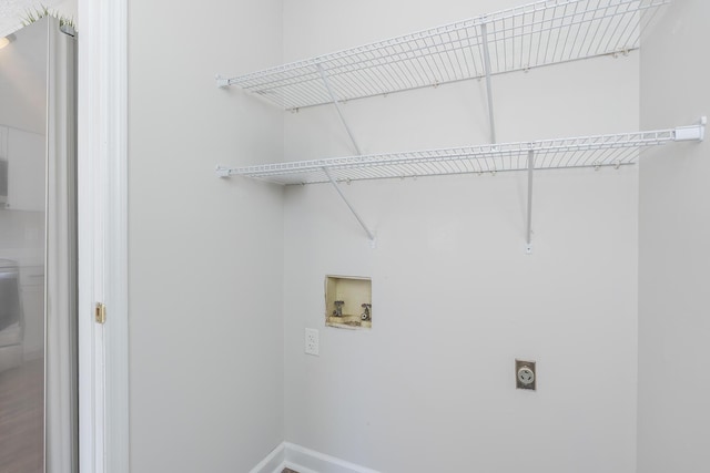 clothes washing area featuring hookup for an electric dryer, hookup for a washing machine, and baseboards