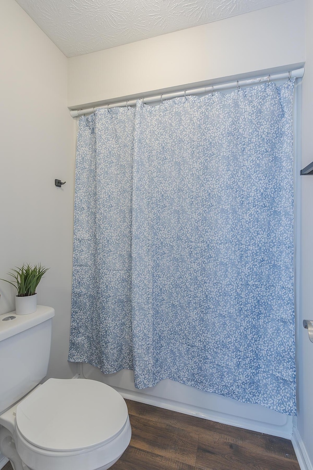 bathroom featuring wood finished floors and toilet