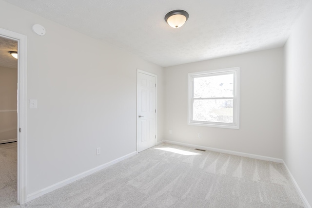 spare room featuring carpet and baseboards