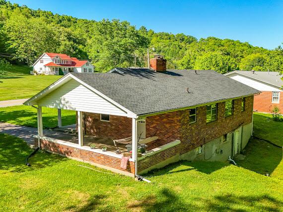 4216 N Ky 11, Cannon, KY 40923 - back of property with a lawn, a shingled roof, a chimney, and a wooded view