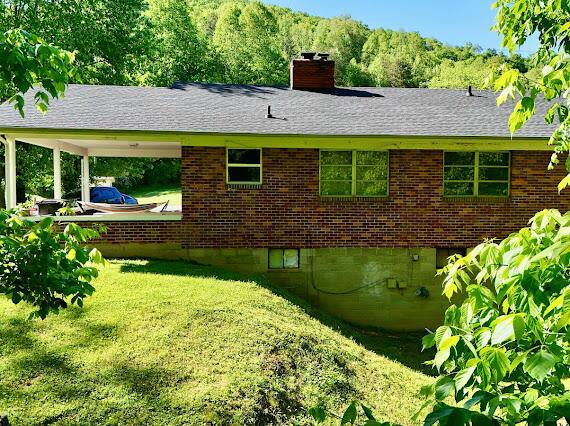 4216 N Ky 11, Cannon, KY 40923 - view of home's exterior featuring a chimney, a lawn, brick siding, and roof with shingles