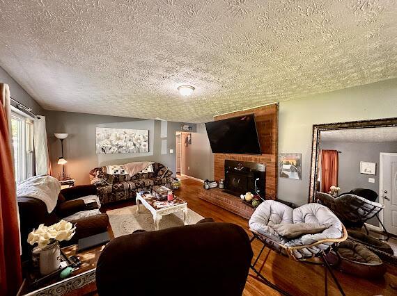 4216 N Ky 11, Cannon, KY 40923 - living room with a textured ceiling, wood finished floors, and a fireplace