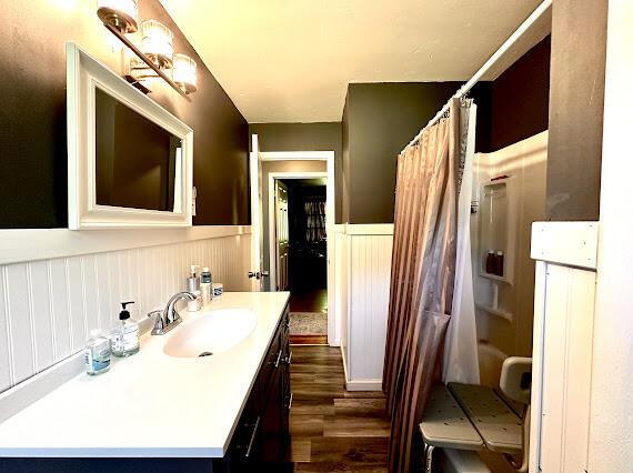 4216 N Ky 11, Cannon, KY 40923 - bathroom featuring a wainscoted wall, wood finished floors, a shower with shower curtain, and vanity