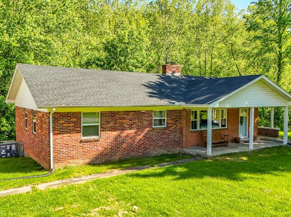 4216 N Ky 11, Cannon, KY 40923 - back of house with a chimney, brick siding, a lawn, and a shingled roof