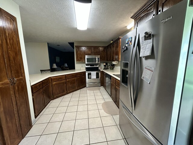 296 Ferry Rd, Somerset, KY 42503 - kitchen featuring appliances with stainless steel finishes, light tile patterned floors, light countertops, dark brown cabinets, and a textured ceiling