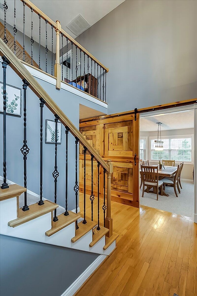 835 Isaac Shelby Cir, Frankfort, KY 40601 - staircase featuring wood-type flooring, a towering ceiling, and a chandelier