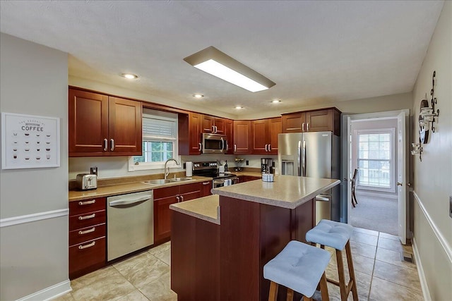 835 Isaac Shelby Cir, Frankfort, KY 40601 - kitchen with appliances with stainless steel finishes, a sink, a kitchen bar, a center island, and light countertops