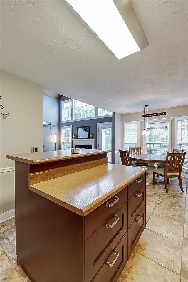 835 Isaac Shelby Cir, Frankfort, KY 40601 - kitchen featuring a center island, pendant lighting, light countertops, baseboards, and a textured ceiling