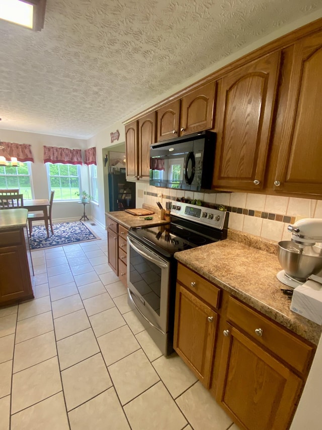 45 Rons Pond Rd, Corbin, KY 40701 - kitchen with electric stove, black microwave, decorative backsplash, brown cabinets, and a textured ceiling