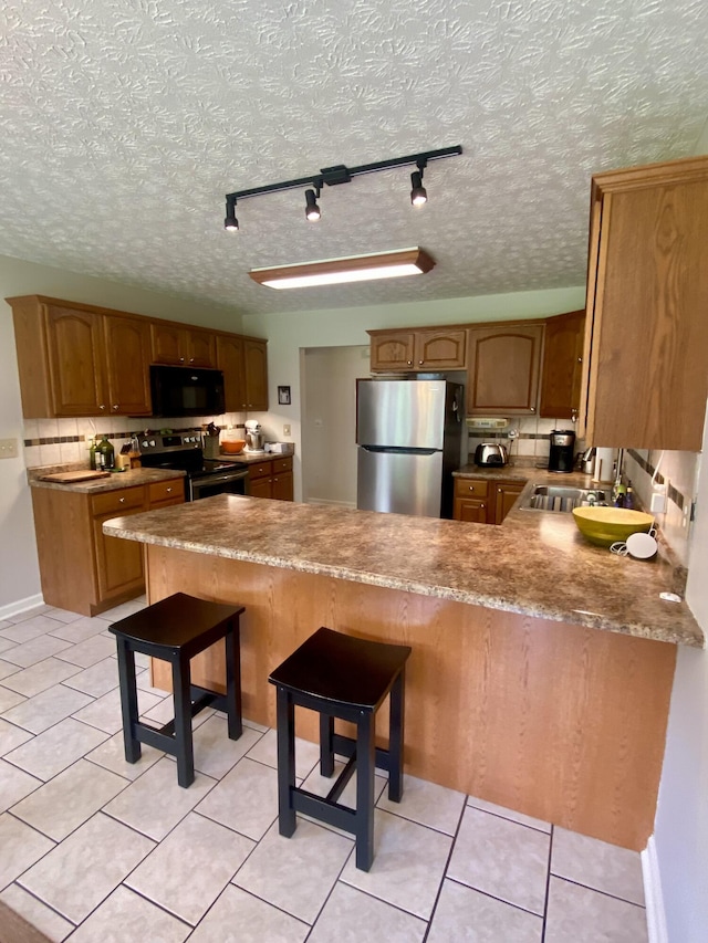 45 Rons Pond Rd, Corbin, KY 40701 - kitchen with stainless steel appliances, a peninsula, rail lighting, a sink, and light tile patterned flooring