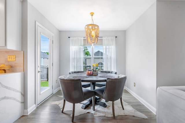 dining space with wood finished floors, a chandelier, and baseboards