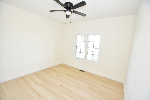 empty room featuring wood finished floors, baseboards, and a ceiling fan