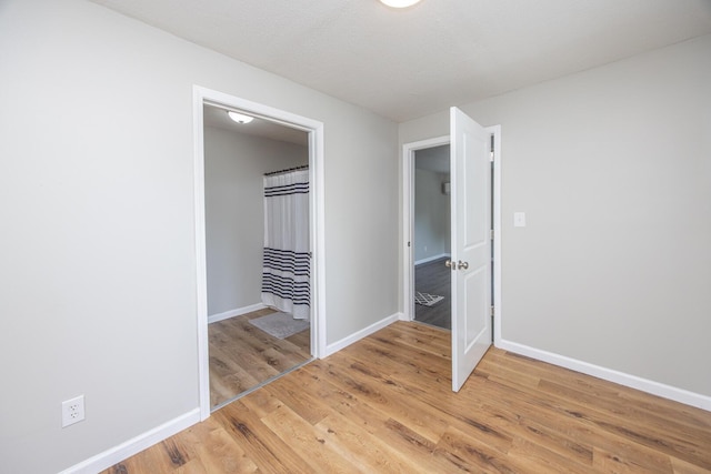 unfurnished bedroom featuring light wood finished floors and baseboards