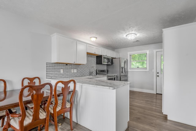 524 Joel St, Lexington, KY 40508 - kitchen with stainless steel appliances, a textured ceiling, backsplash, white cabinets, and dark wood-style floors