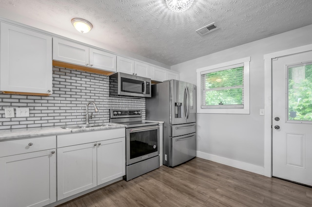 524 Joel St, Lexington, KY 40508 - kitchen with stainless steel appliances, white cabinetry, dark wood-style flooring, a textured ceiling, and light stone countertops
